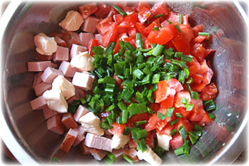 Салат с колбасой, сыром и помидорами.