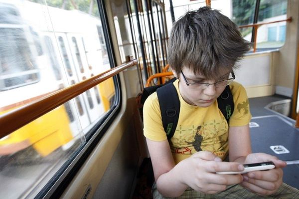 Мальчик в автобусе с телефоном